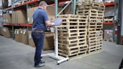 Employee using a manufacturing execution system (MES) in a warehouse, monitoring production and managing operations.
