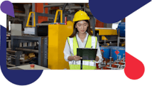 Woman on manufacturing shop floor with hardhat looking at a table, Accruent facility asset management software platform