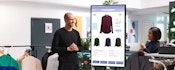 A retail employee demonstrates the latest retail trends with an interactive demo, engaging with an interested customer.