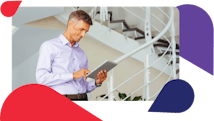 Smiling man using tablet in stairwell while taking advantage of mobile space planning capabilities of space planning software