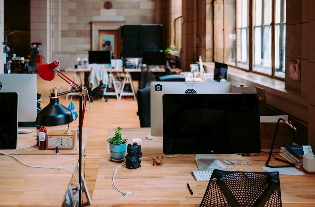 A desk with computers and a lamp