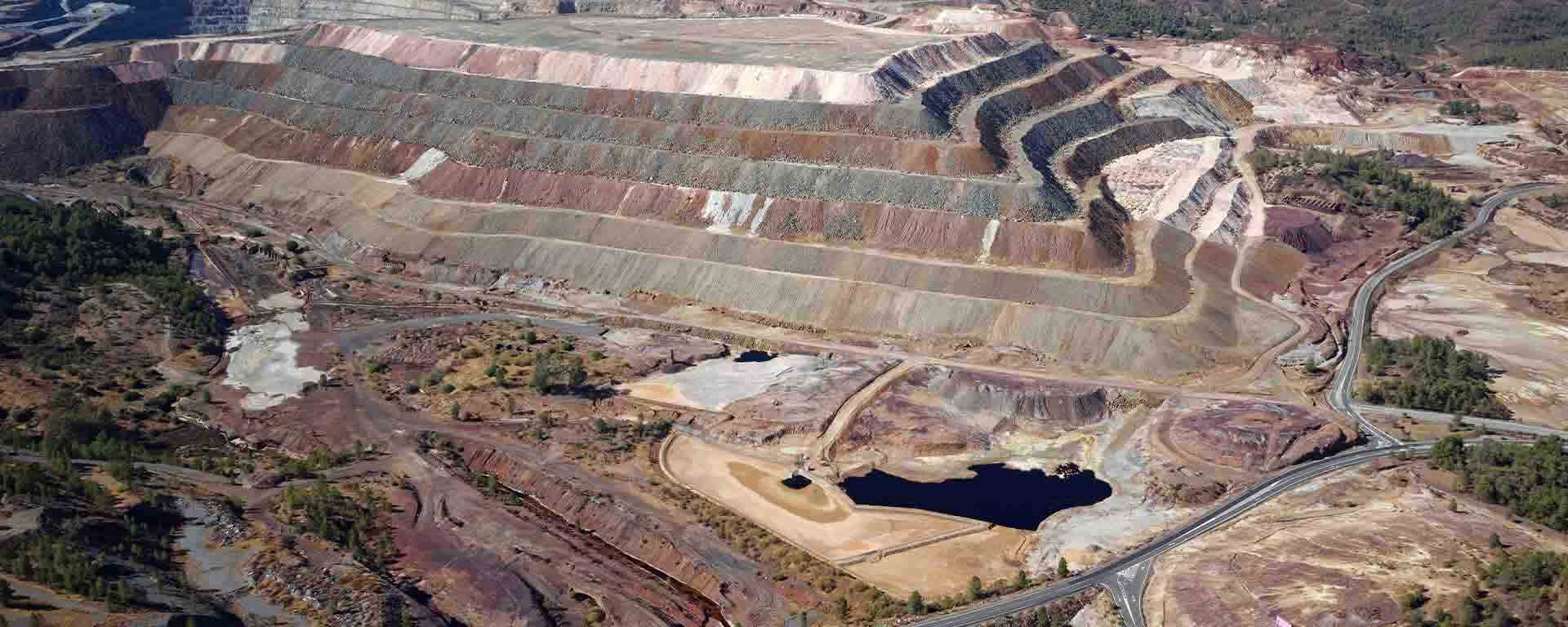 Aerial view of a large open-pit mining site with terraced excavation.